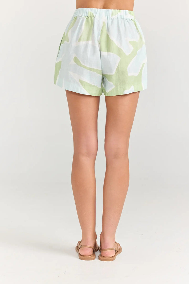 Light green shorts with white patterns worn by a person on a white background