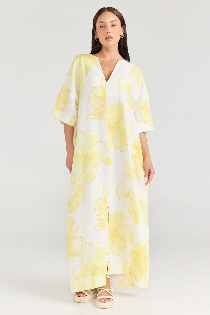 Woman wearing a yellow floral dress on a white background