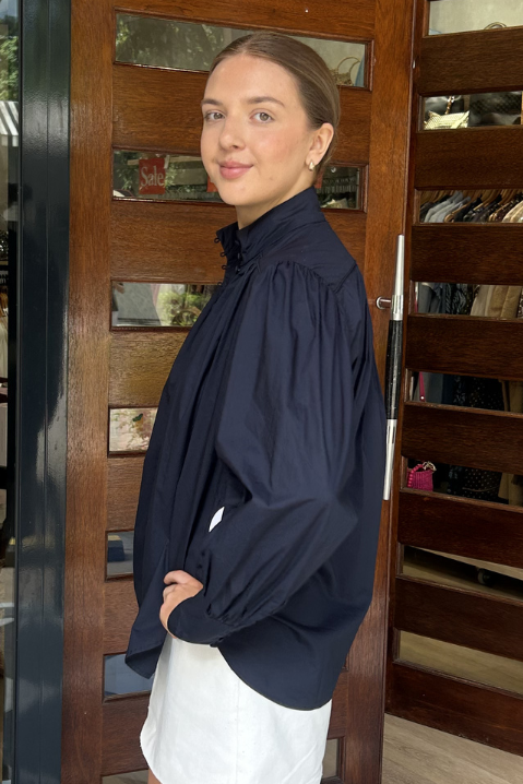 Woman standing in front of a store entrance with clothing displayed inside