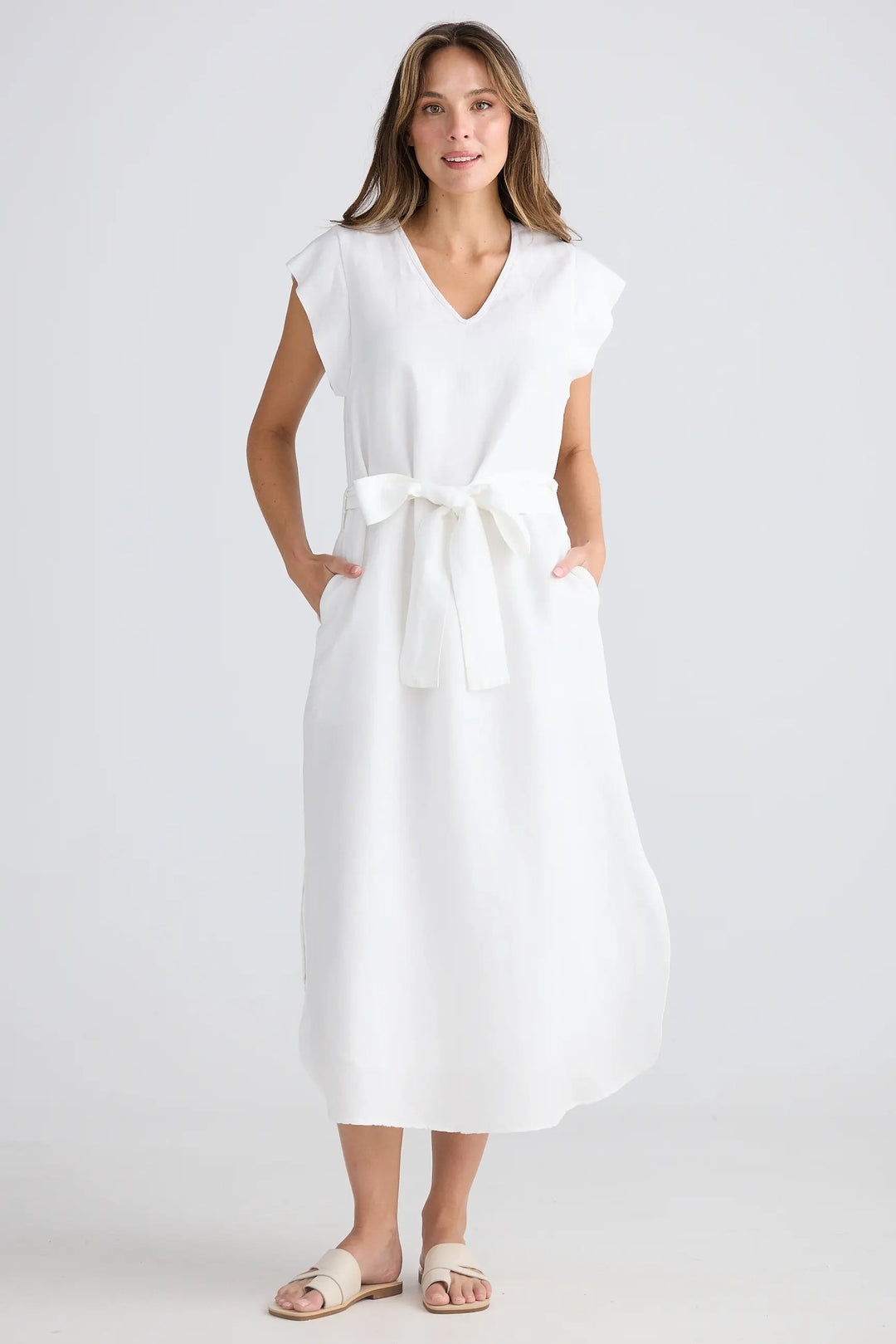 Woman wearing a white dress on a plain background