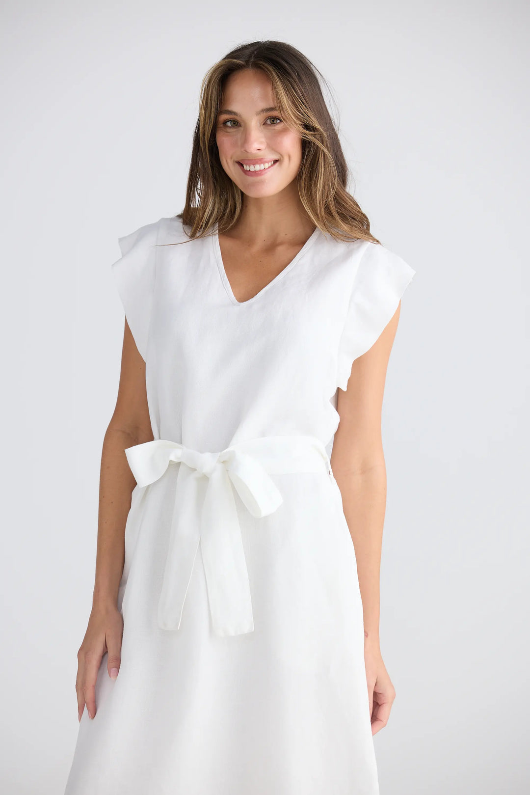 Woman wearing a white dress with a bow on a white background