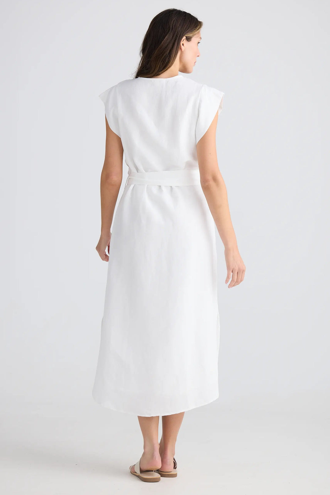 Woman wearing a white dress on a plain background