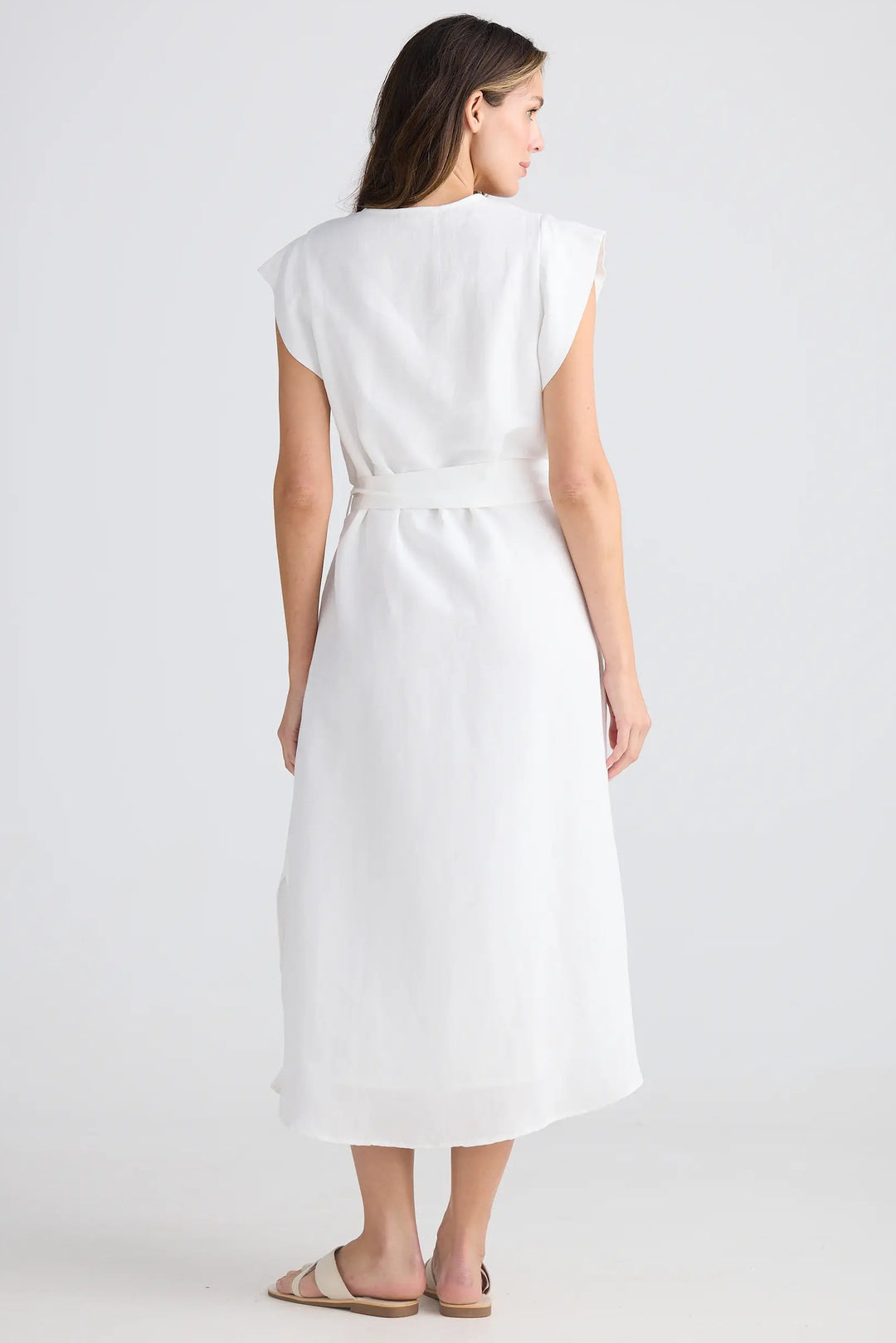 Woman wearing a white dress on a plain background
