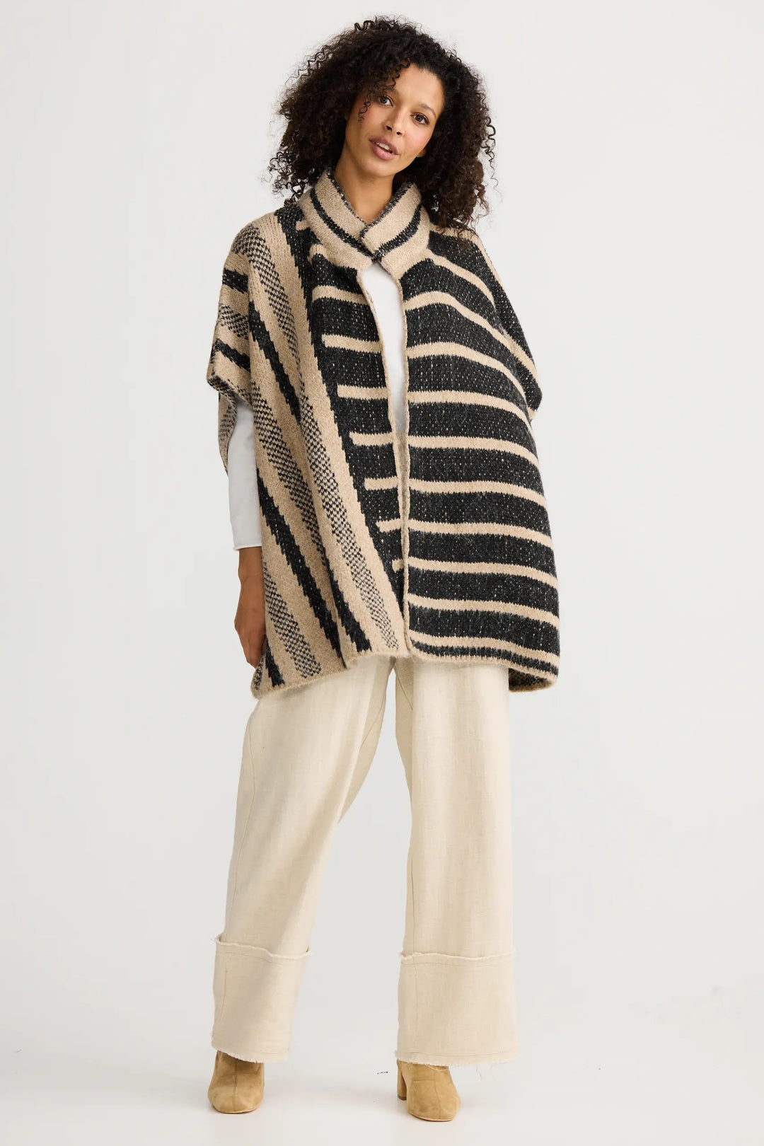 Woman wearing a striped poncho on a white background