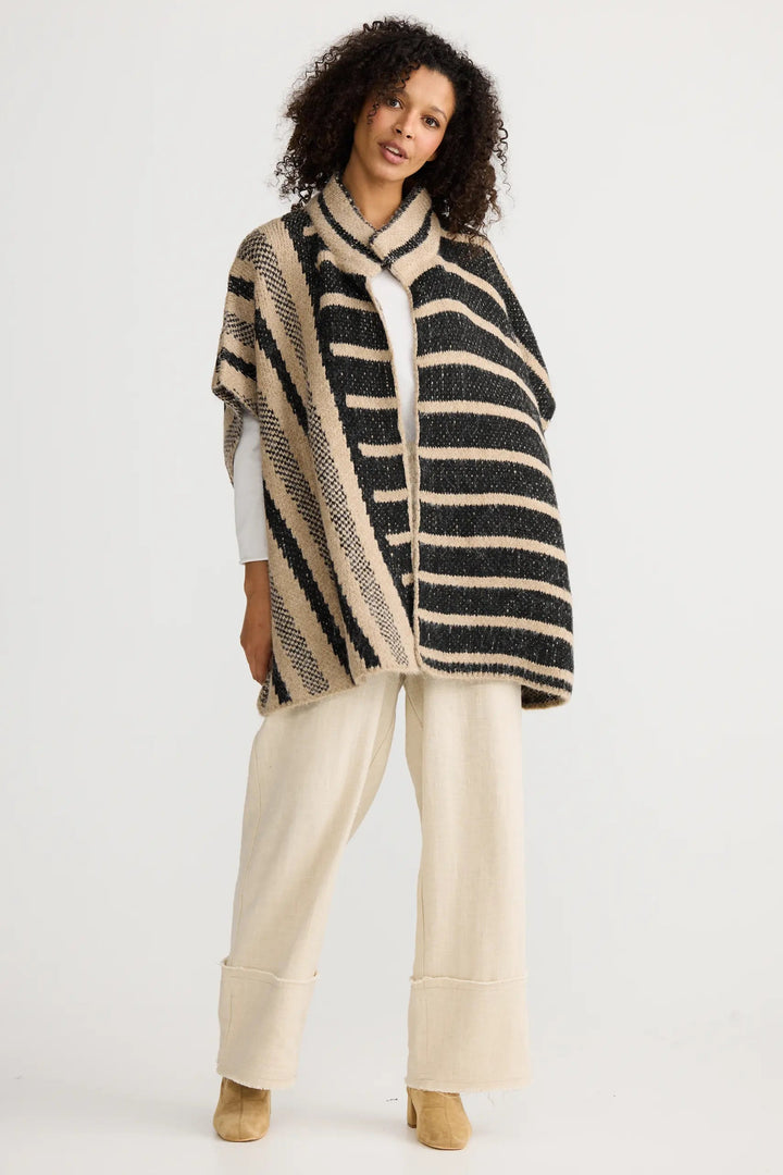 Woman wearing a striped poncho on a white background
