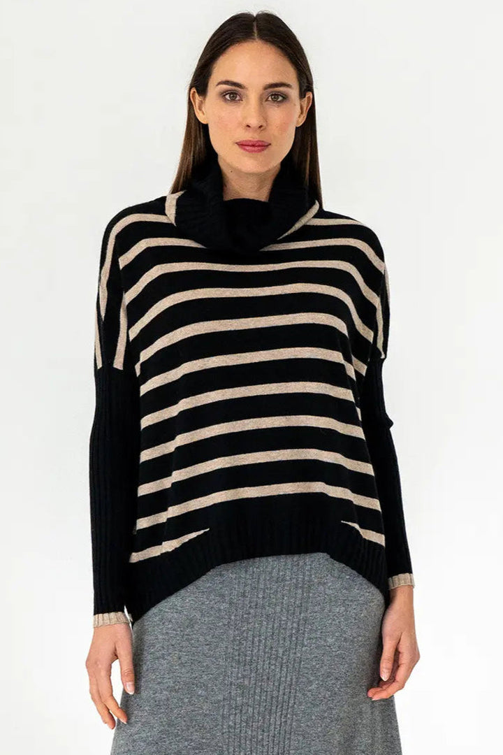 A woman wearing a black and beige striped knit sweater with a large roll neck.