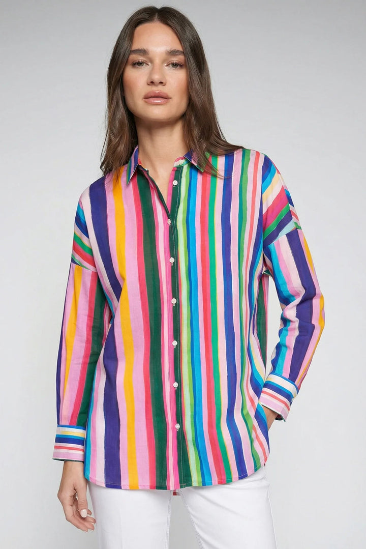 Woman wearing a colorful striped shirt against a plain background