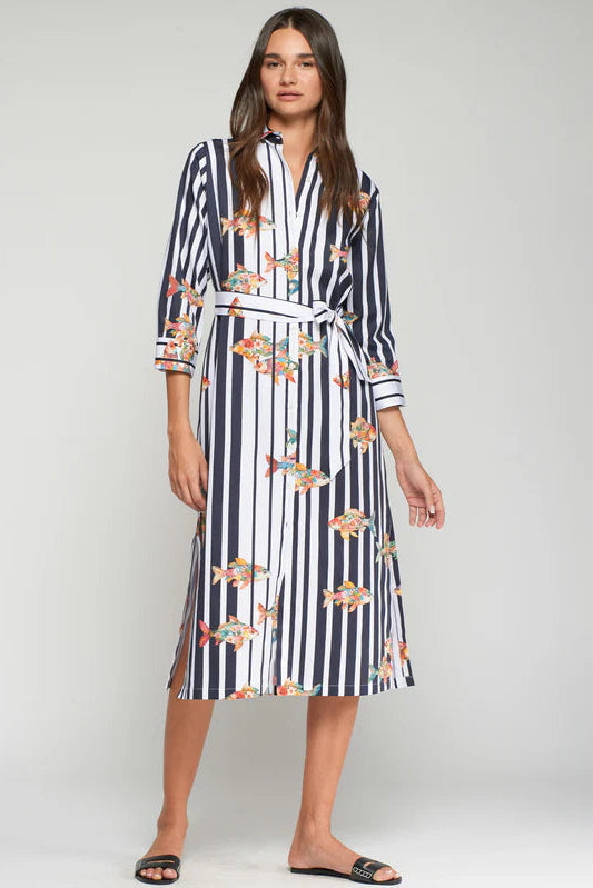 Woman wearing a navy and white striped dress with floral patterns on a plain background
