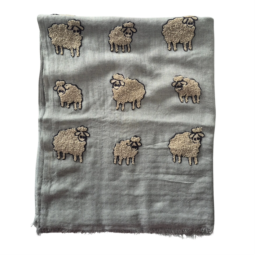Scarf with embroidered sheep design on a gray background