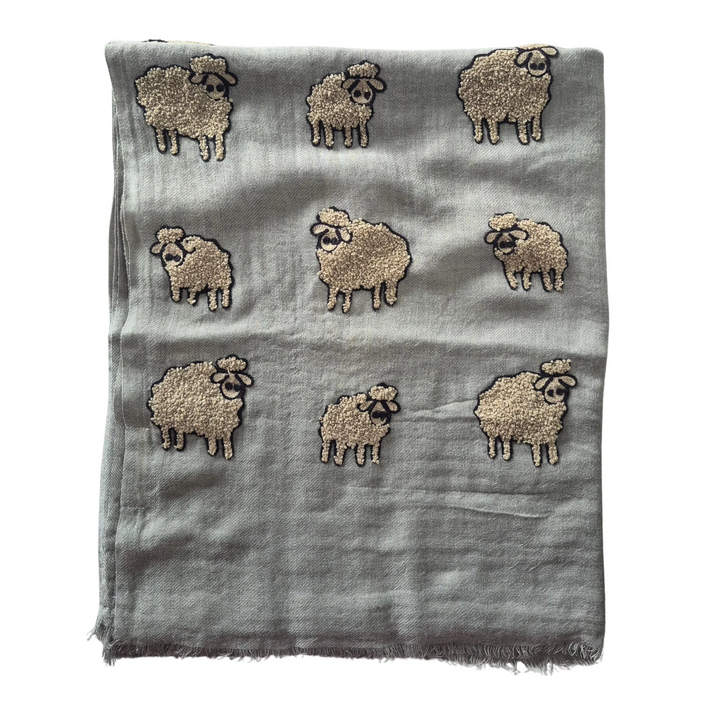 Scarf with embroidered sheep design on a gray background