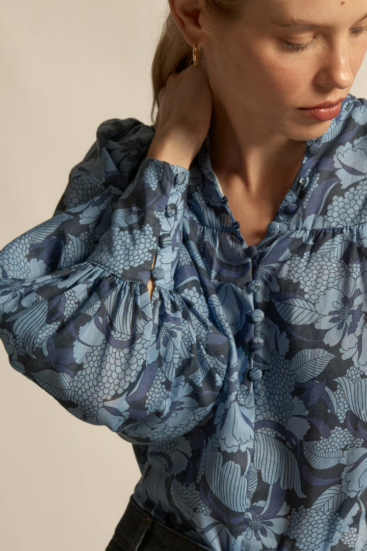 Woman wearing a blue floral blouse against a neutral background