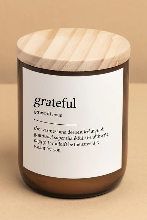 A candle jar with a wooden lid, labeled 'grateful' with a definition underneath.