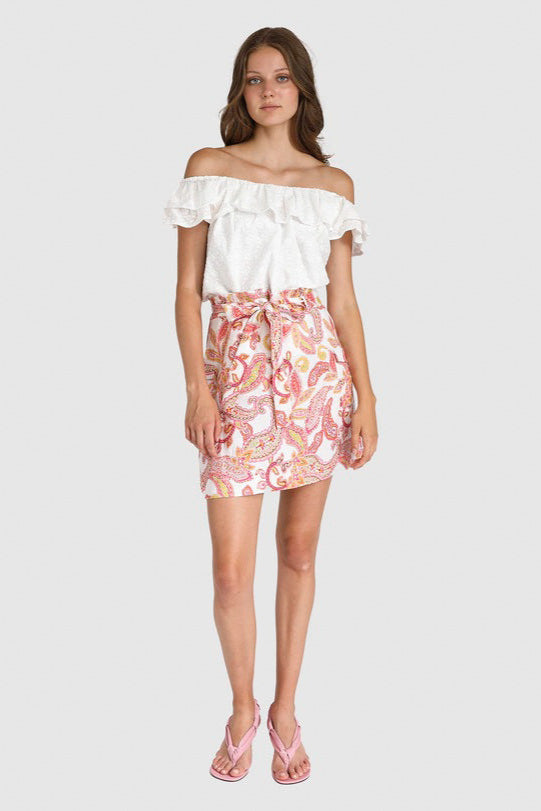 A woman modeling a safari-style mini skirt with a paisley print, featuring a detachable tie waistband and large cargo pockets.